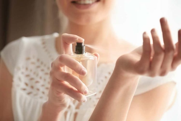 Elegant woman applying perfume Elegant woman applying perfume
